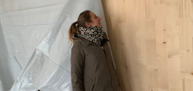 Eine Frau begutachtet die Wände - Aufbau der Holzwände ist zu sehen . Bauarbeiten in der Kita Hegenberg Gruppen- und Schlafräume, Bereich zum Turnen, Mensa, Arbeits- und Personalaufenthaltsräume sowie Elterncafé im Bau .